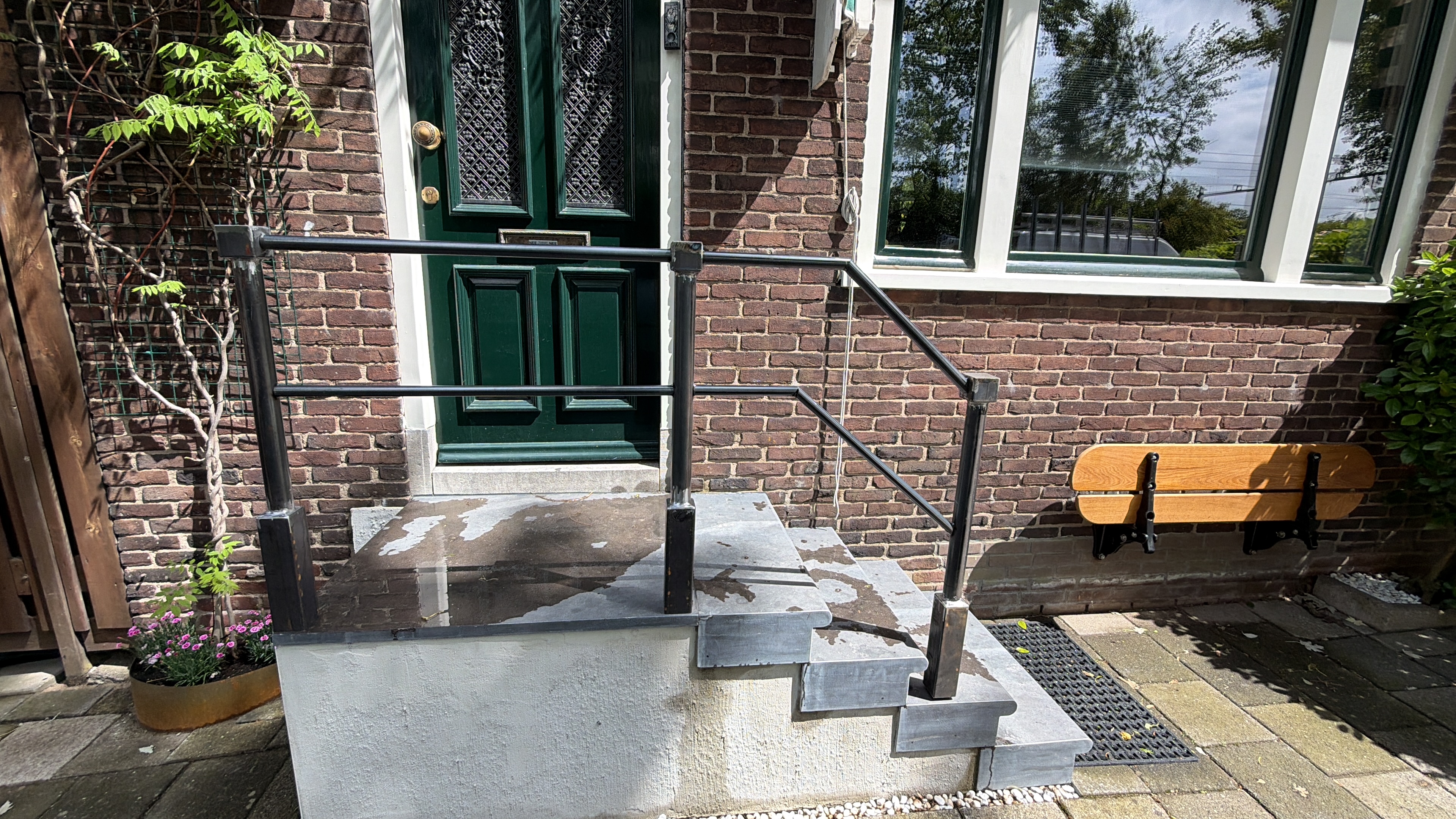 Stalen balustrade met contrasterende gevel en voordeur, maatwerkproject Dordrecht
