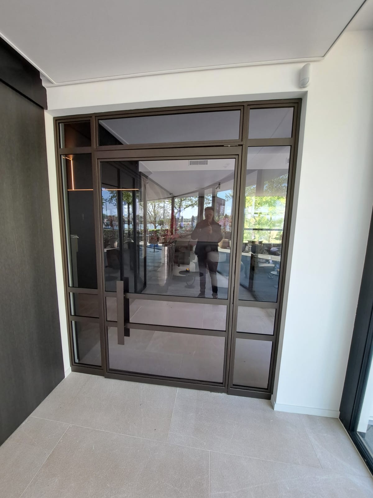 Stalen taatsdeuren in Anonic Dark Brons met rookglas bij Restaurant Parkheuvel, Rotterdam, zicht op scharnierdetail