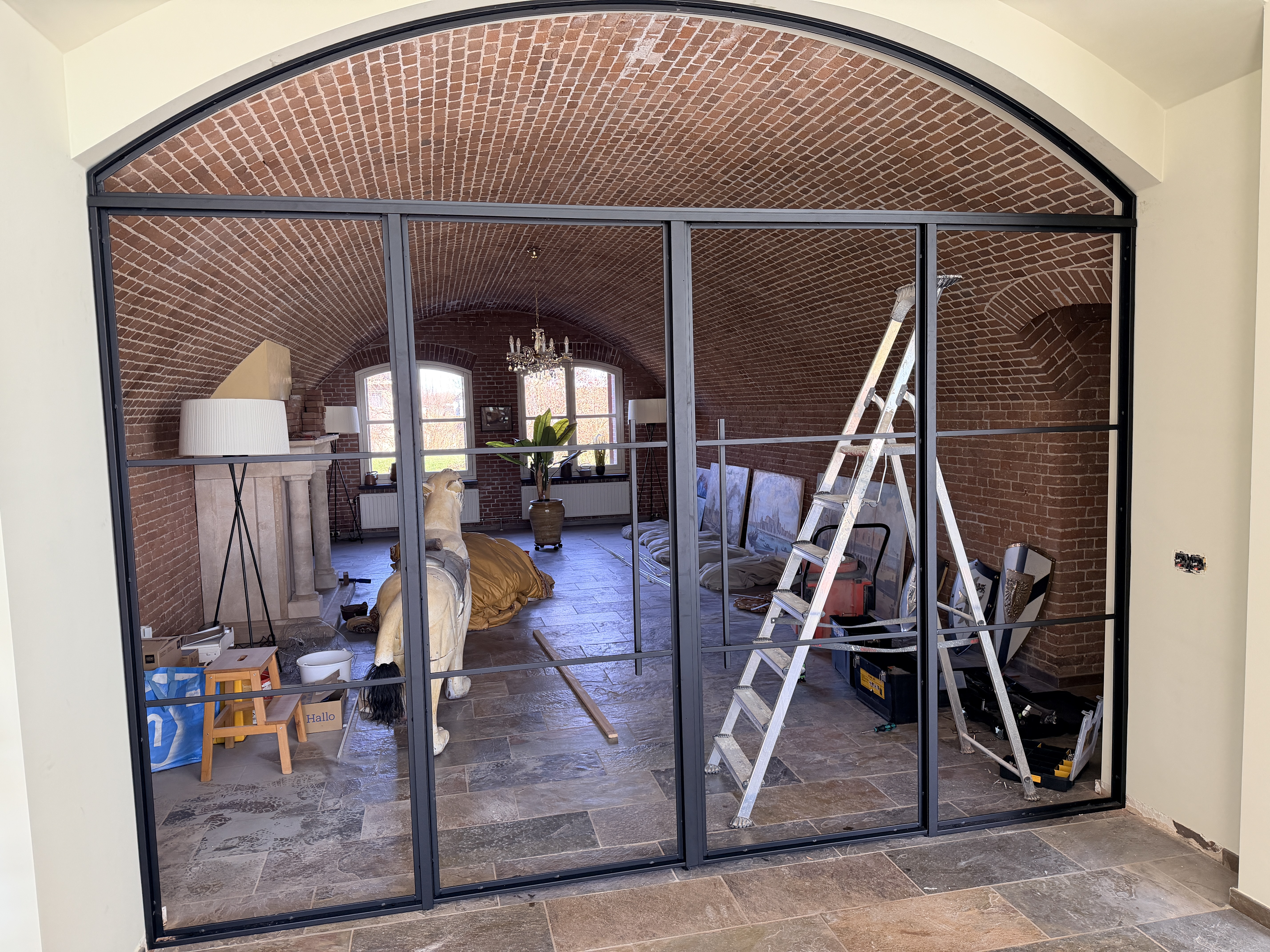 Hoekdetail van de stalen toogdeur en de vloer in Werkendam, met nadruk op de naadloze integratie in het interieur
