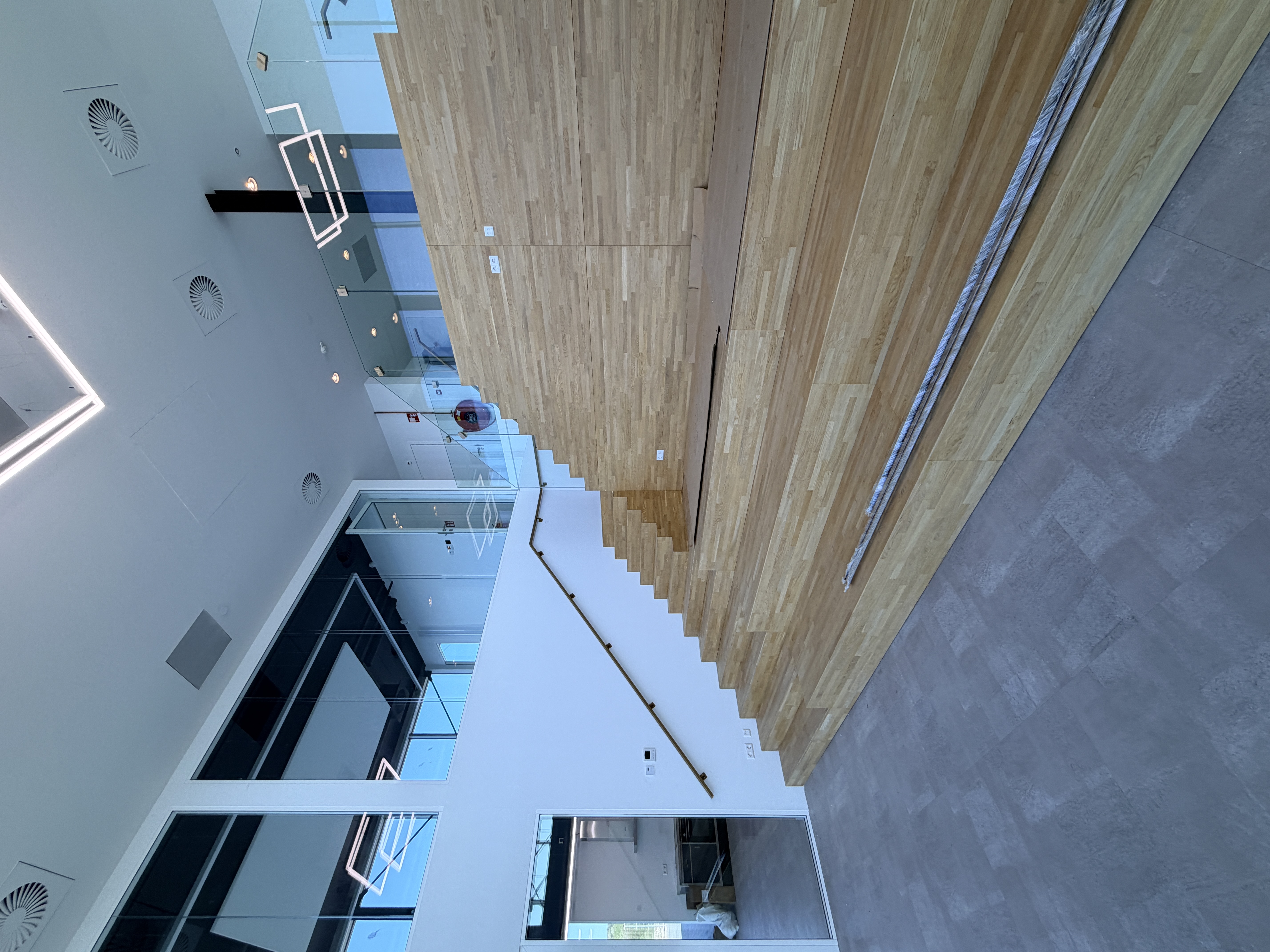Goud gecoate stalen trapleuning in modern kantoorpand te Rotterdam, detail bevestiging en slank profiel langs trap
