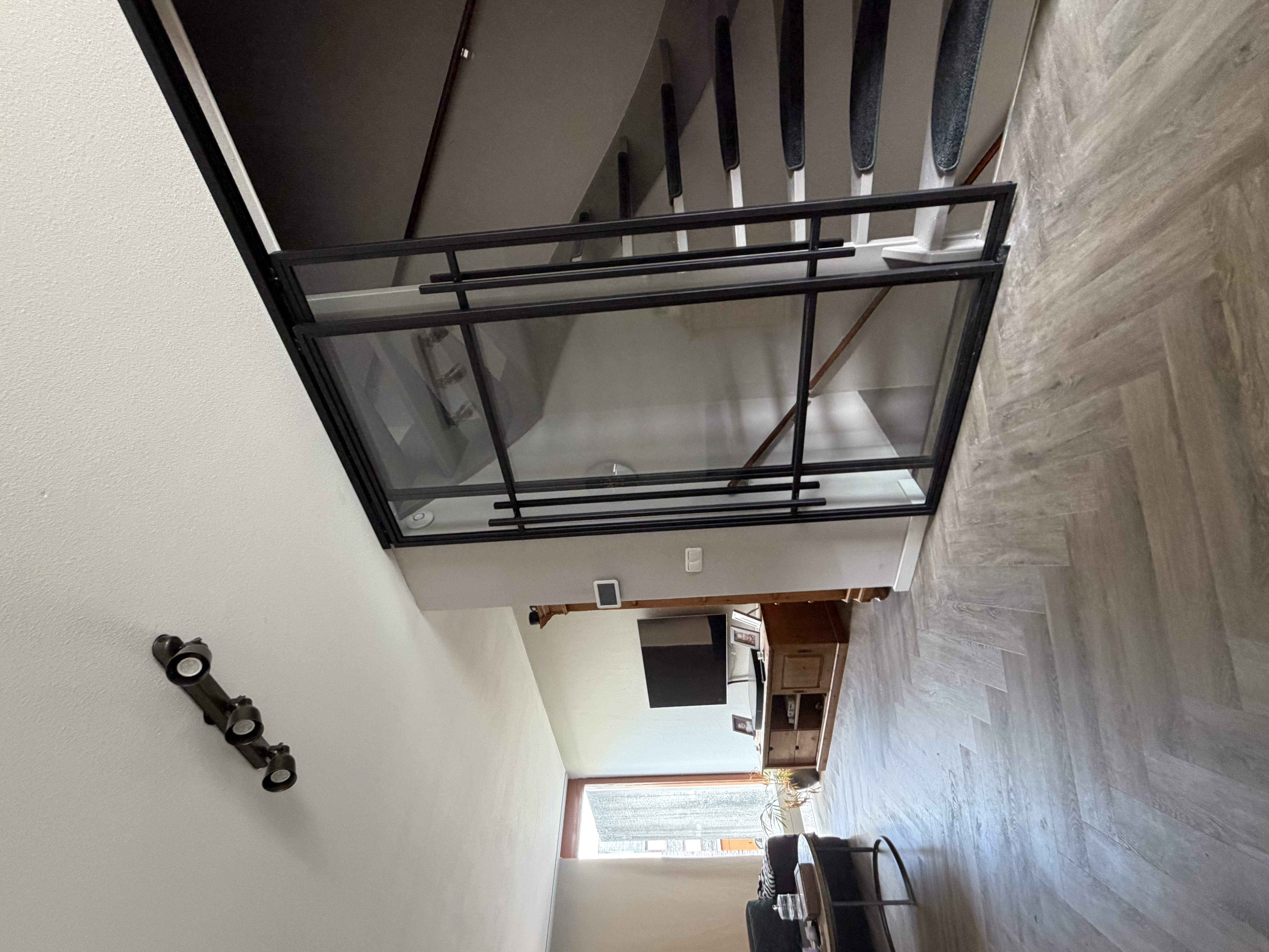 Zijaanzicht schuifdeuren en open eettafel, contrast staalprofiel en interieur in Papendrecht