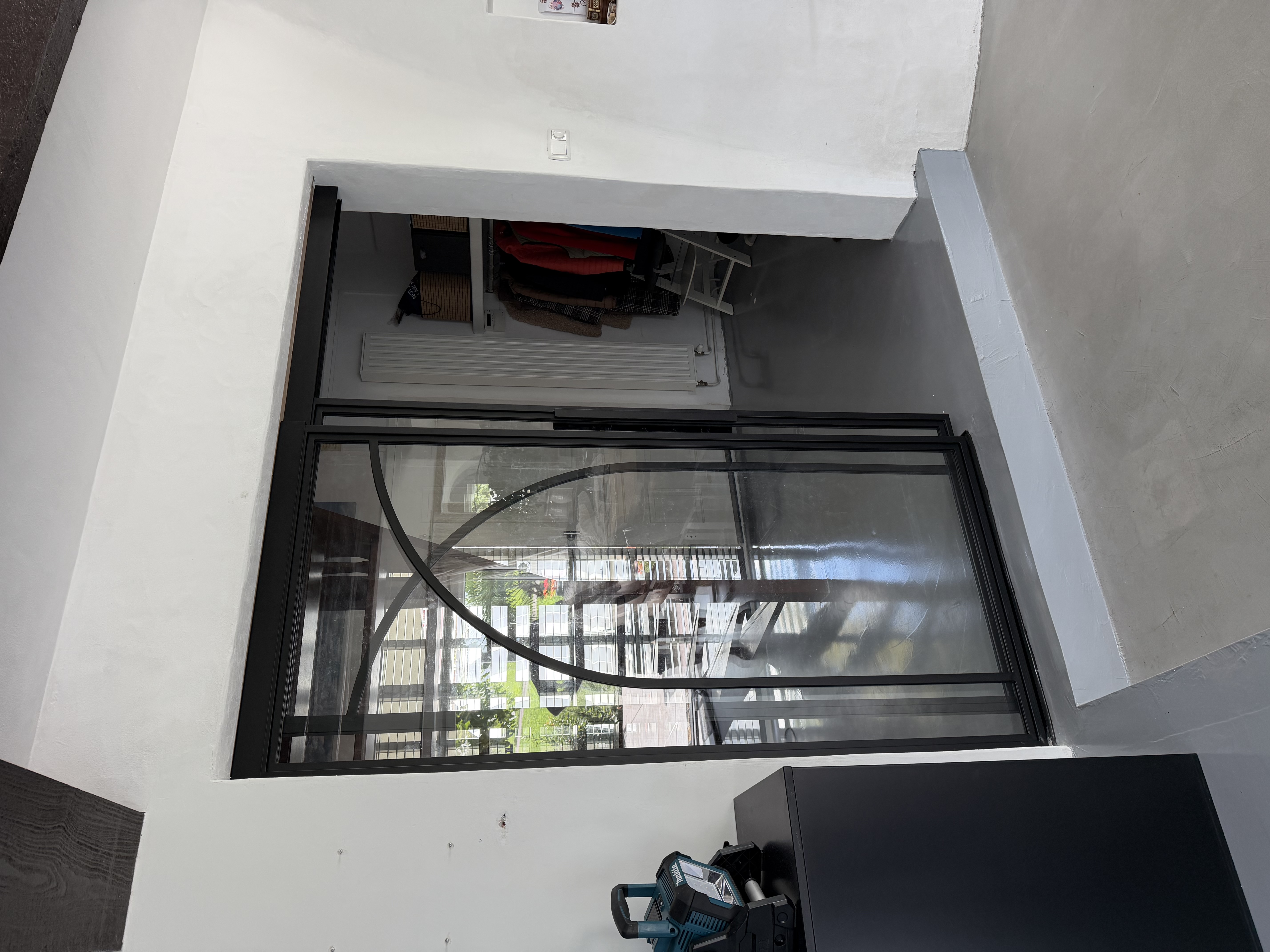 Detail van gebogen stalen profilering over schuifdeur en zijlicht in Zevenhuizen, RAL 9005 structuur