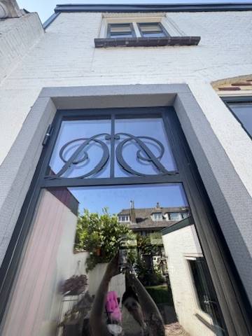 Stalen buitendeur met klassiek smeedwerk in Oegstgeest