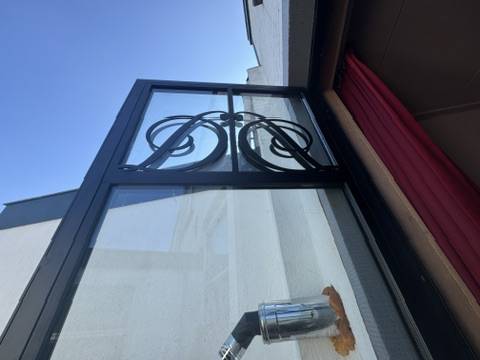 Stalen buitendeur met klassiek smeedwerk in Oegstgeest