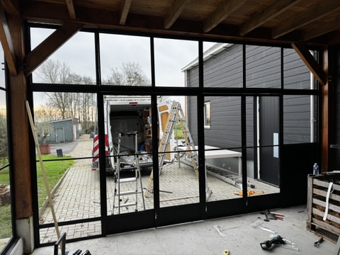Stalen pui met geïntegreerd hondenluik naast de vouwwand